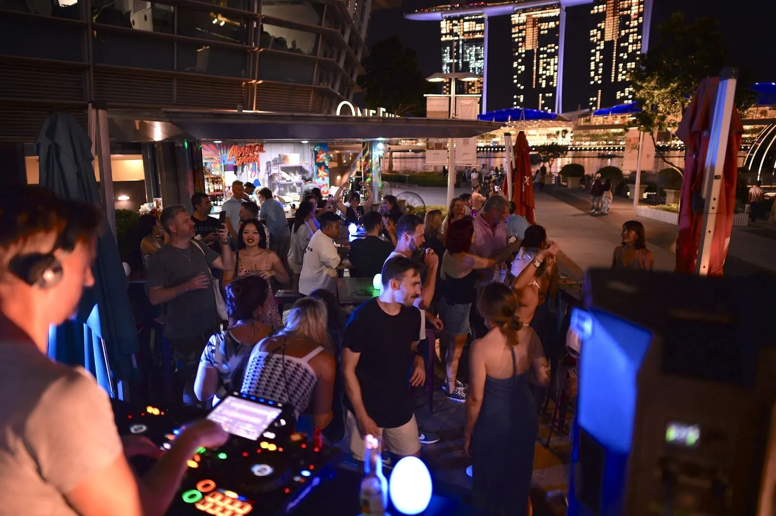 View from the DJ booth across a packed dance floor at night