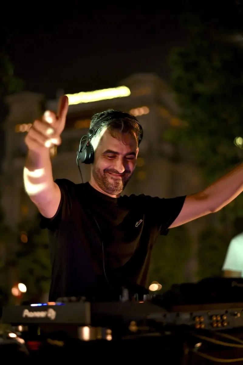 Driguo raising his hand to the crowd during a night set
