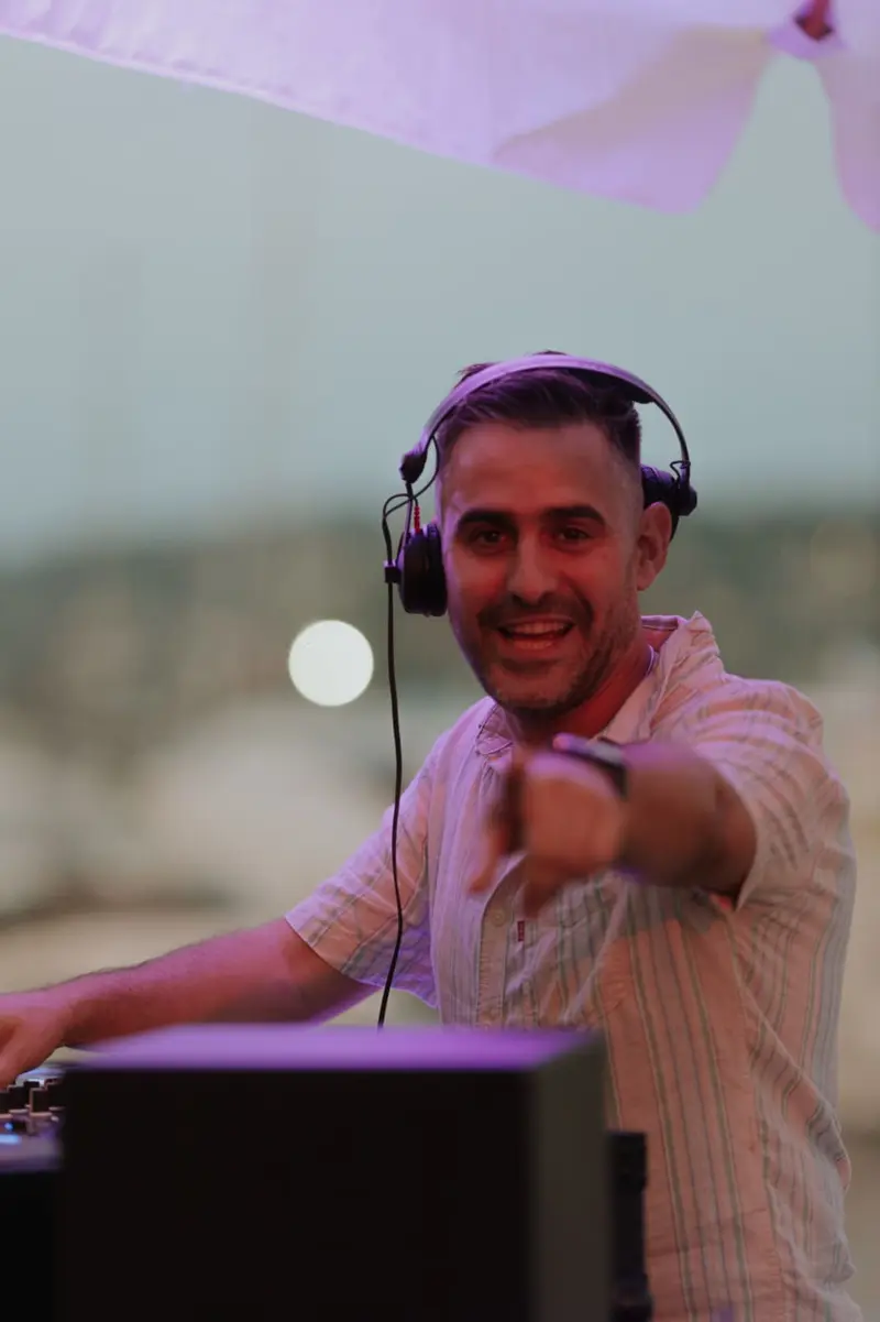 Driguo smiling and pointing to the crowd from the booth