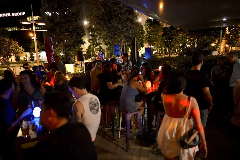 Guests mingling under the trees at an outdoor terrace party